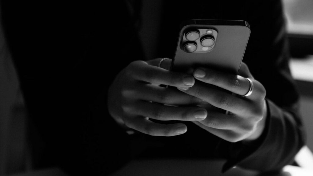 Black and white photo of someone holding their phone. 